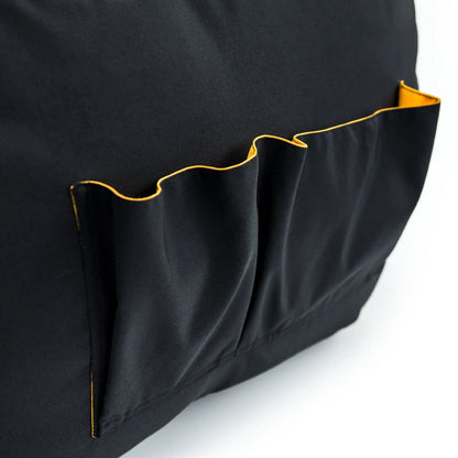 A close-up photo of a black bag with a yellow pocket on the side.