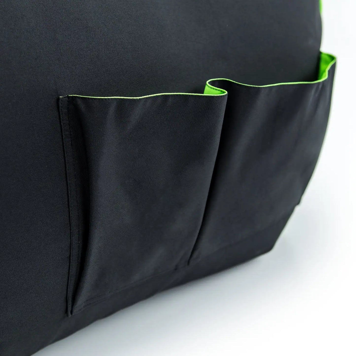 A black bag cover with a green pocket on the side, close-up.